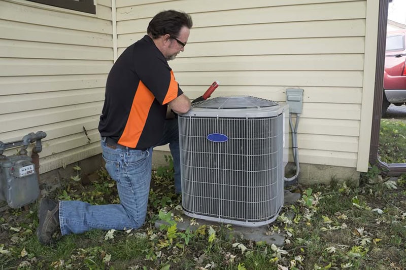 Technician performing HVAC maintenance at residential home in San Diego, California.